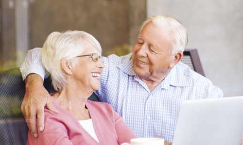 lifetime of smiles senior couple smiling at computer